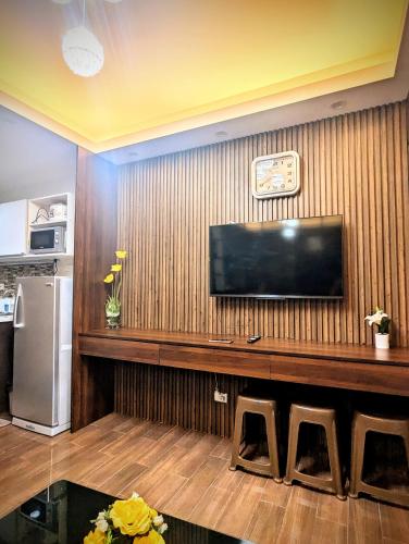 a living room with a flat screen tv on a wall at 1 bedroom Cozy Escape in Manila