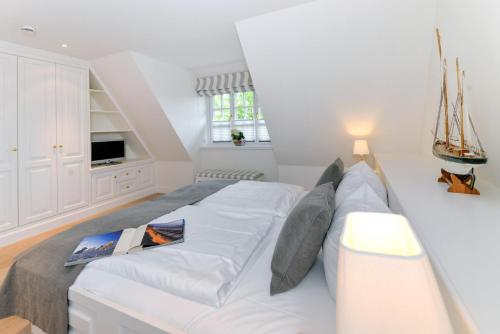 a bedroom with a large bed with white sheets and pillows at LITZKOW 12802 in Morsum