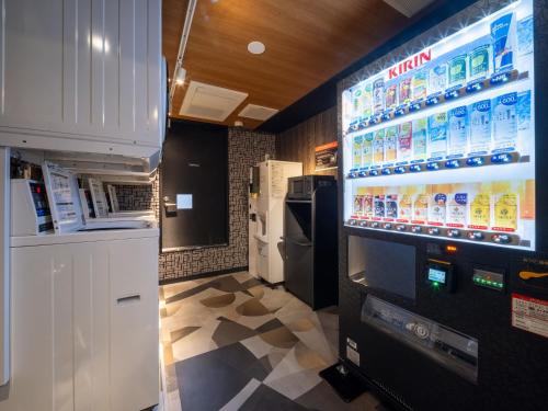 a vending machine in a store with a large screen at APA Hotel Akabane Iwabuchi Ekimae in Tokyo