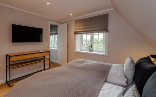 una camera da letto con un letto e una TV a schermo piatto di LITZKOW 16201 ad Archsum