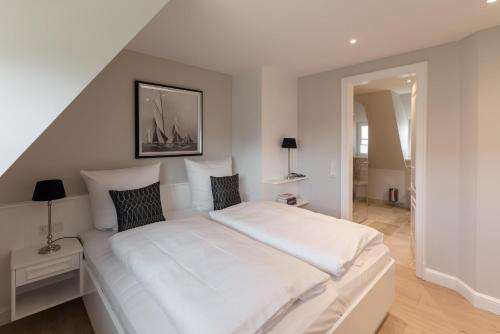 un grande letto bianco in una stanza con scala di LITZKOW 16203 ad Archsum