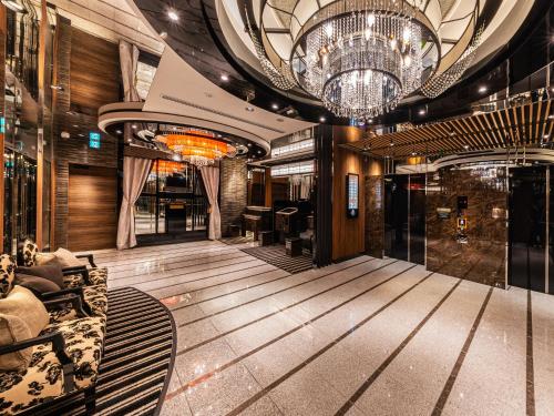 a lobby of a building with a chandelier at APA Hotel Akabane Iwabuchi Ekimae in Tokyo