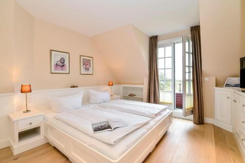 un letto bianco in una stanza con una finestra di LITZKOW 12503 a Morsum