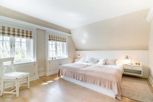 una camera da letto bianca con un letto e una sedia di LITZKOW 14204 a Morsum