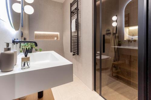 a bathroom with a white sink and a shower at Lungolago Modern FD Apartments in Como