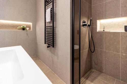 a bathroom with a shower with a glass door at Lungolago Modern FD Apartments in Como