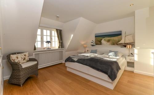 a white bedroom with a bed and a chair at LITZKOW 15001 in Morsum