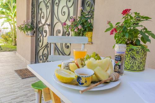 a plate of fruit on a table with a glass of orange juice at Ocampo Catamarca in San Fernando del Valle de Catamarca