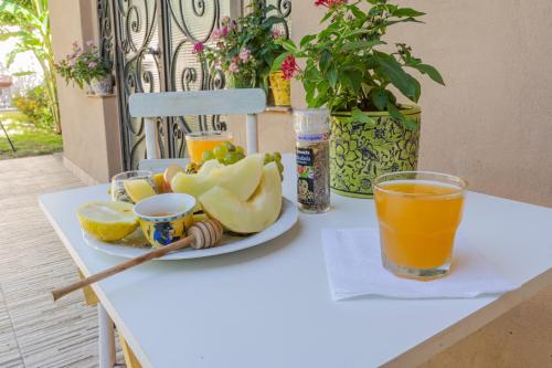 a plate of fruit and orange juice on a table at Ocampo Catamarca in San Fernando del Valle de Catamarca