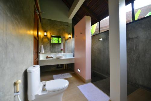 a bathroom with a toilet and a sink at Bor Saen Pool Villa in Bor Saen