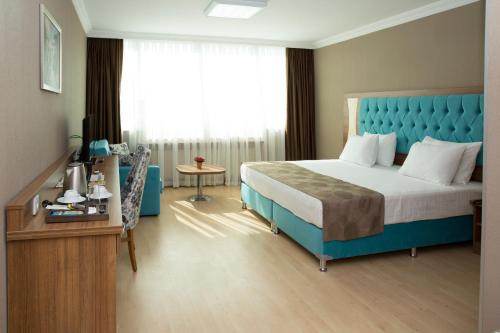 a bedroom with a bed with a blue headboard and a window at Golden Lounge Hotel in Istanbul