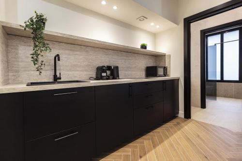 a kitchen with black cabinets and a sink at Lungolago Modern FD Apartments in Como