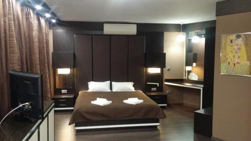 a bedroom with a large bed with two white towels at Studio Mountain Dreams Deluxe in Sapareva Banya