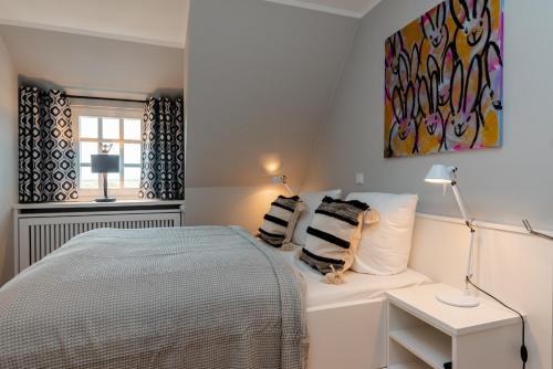 una camera da letto con un letto e un quadro sul muro di LITZKOW 16103 ad Archsum