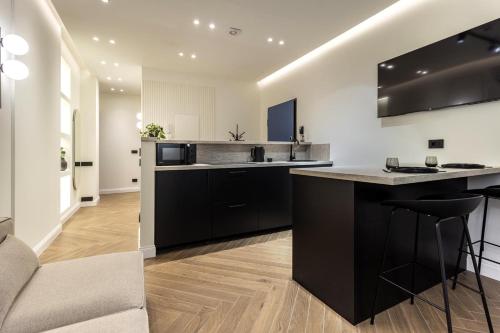 a kitchen with black and white appliances and a counter at Lungolago Modern FD Apartments in Como
