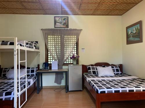 a room with two bunk beds and a desk at Valley Breeze Resort in Gabaldon