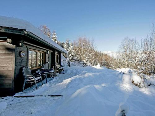 a snow covered cabin with tables and chairs in the snow at Yosi im Brixental in Wörgler Boden