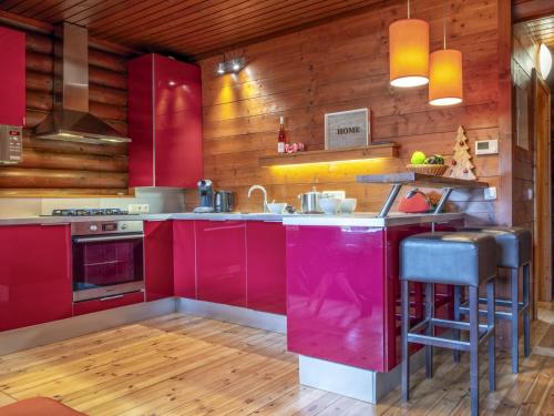 a kitchen with red cabinets and wooden walls at Yosi im Brixental in Wörgler Boden
