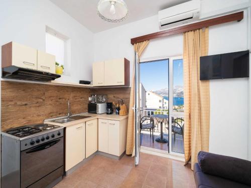 a kitchen with a stove top oven next to a balcony at Apartments Senjo - One Bedroom Apartment with Balcony and Sea View 4 adults Apartman 3 in Cavtat