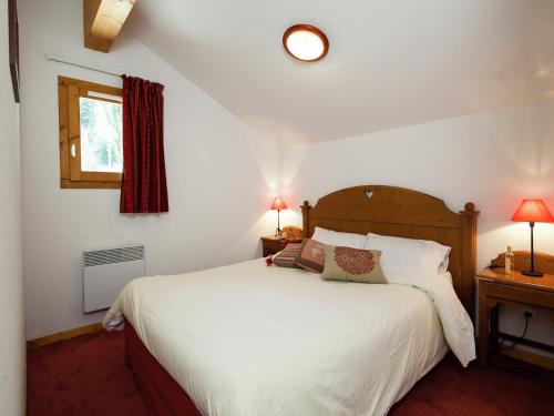 une chambre avec un lit blanc et une fenêtre dans l'établissement Chalet-style apartment, à Valfréjus