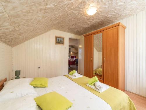 a bedroom with a large white bed with yellow pillows at Villa Desin - Three Bedroom Apartment with Terrace and Garden View in Molunat