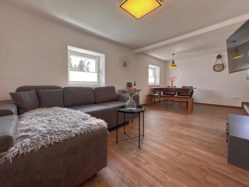 a living room with a couch and a table at Freistehendes Haus mit Ofen, Terrasse und Garten in Stadlern