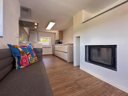 a living room with a couch and a fireplace at Freistehendes Haus mit Ofen, Terrasse und Garten in Stadlern