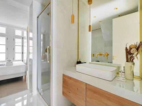une salle de bain avec un lavabo blanc et un miroir dans l'établissement Sublim Apartement Center of Paris Montmartre, à Paris