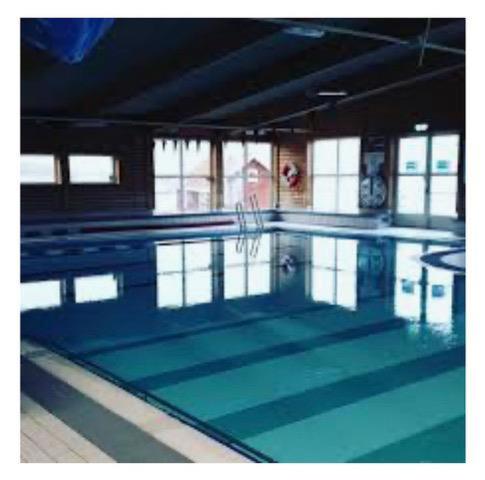 a large swimming pool with blue water at Amazing Home In Väjern With 4 Bedrooms And Wifi in Väjern