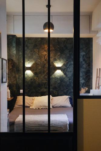 - une chambre avec un lit et un mur orné de plantes dans l'établissement Modern apartment with balcony and AC walk to tramway near center, à Nice