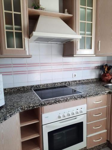 a kitchen with a stove top oven in a kitchen at Mi bonito apartamento del Portil in El Portil