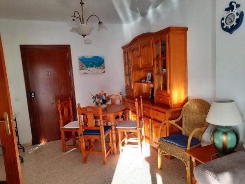 a kitchen with a table and chairs and a dining room at Mi bonito apartamento del Portil in El Portil