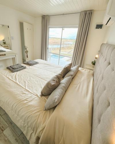a bedroom with a large bed with a window at Cabañas Titina's Lake in Potrero de Garay