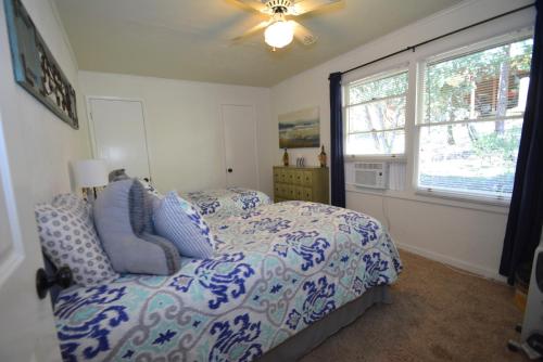 a bedroom with a blue and white bed and a window at Ledge House-Lake Area in Bass Lake