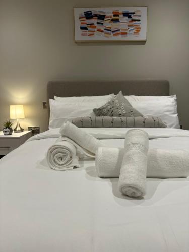a white bed with towels on top of it at Luxury City Centre Loft in Birmingham
