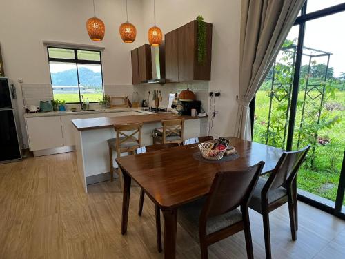 a kitchen with a wooden table and chairs and a dining room at Mai Paddy Cottage, Balik Pulau in Balik Pulau