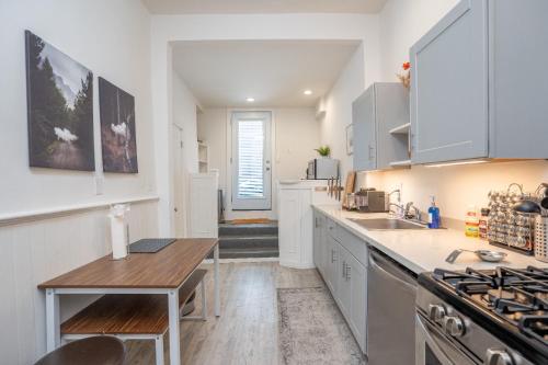 Una cocina con gabinetes blancos y una mesa de madera. en Hayes Valley Home 3Bed by Restaurants, Bars and Shops, en San Francisco
