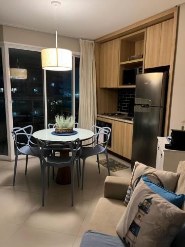 a kitchen and living room with a table and chairs at Estanconfor Vista Mar em Santos in Santos