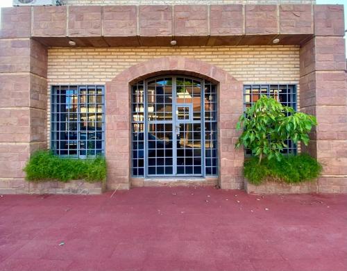 a brick building with two doors and a tree at Mangoty Apartamento in Luque