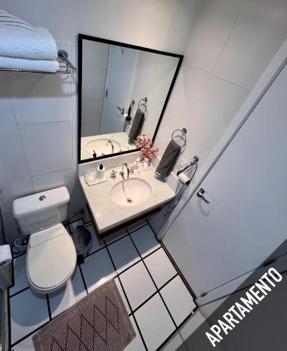 a bathroom with a toilet and a sink and a mirror at Verano Stay Flat Barra Olímpica in Rio de Janeiro