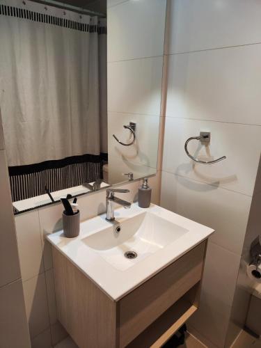 a bathroom with a white sink and a mirror at Céntrico Departamento, Ochagavia in Puerto Montt
