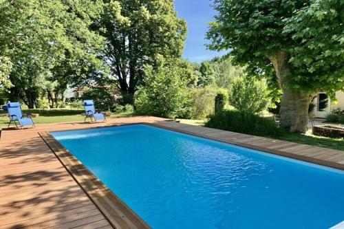 une piscine bleue avec deux chaises et un arbre dans l'établissement in La Fontenelle, Cuisery, à Cuisery