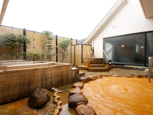 a large pool of water in front of a house at Arima Hot Spring Ryokan Hanamusubi in Kobe