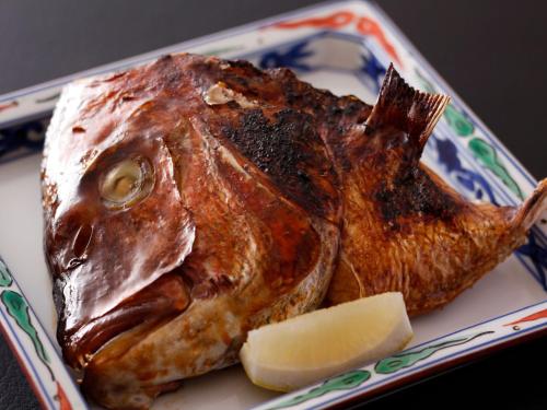 a fish on a plate with a piece of cheese at Arima Hot Spring Ryokan Hanamusubi in Kobe