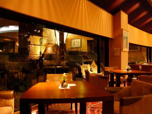 a restaurant with tables and chairs and a fireplace at Arima Hot Spring Ryokan Hanamusubi in Kobe