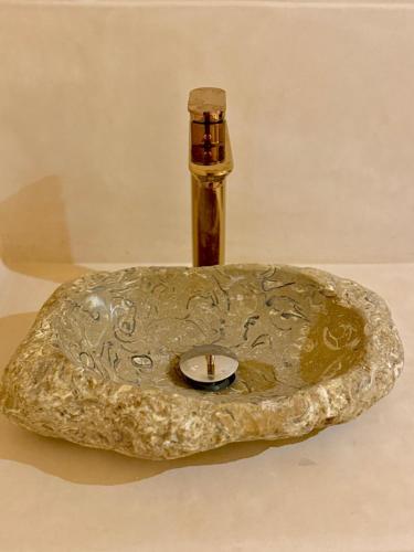 a bronze sink with a bottle in the middle at Playa Surf House in Tamraght Ouzdar