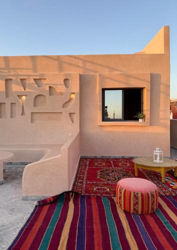 a living room with a table and a rug at Playa Surf House in Tamraght Ouzdar