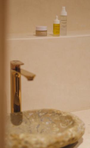 a shelf with two bottles of moisturizers and a sink at Playa Surf House in Tamraght Ouzdar