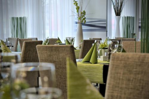 a dining room with tables and chairs with green tablecloths at Hotel Euro in Pardubice