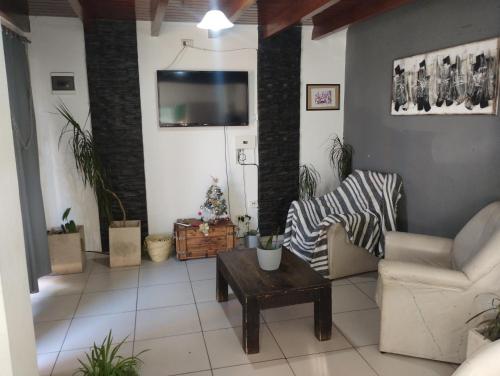 un salon avec une télévision sur un mur dans l'établissement Departamentos Mama carmen, à Mina Clavero